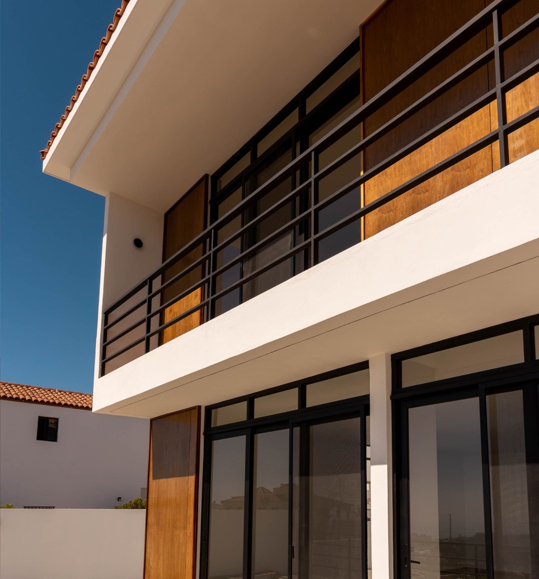 Terraza con puerta principal de madera y cancelería negra