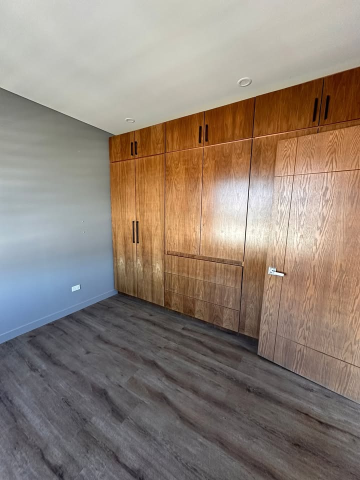Recámara principal con clósets de madera de piso a techo